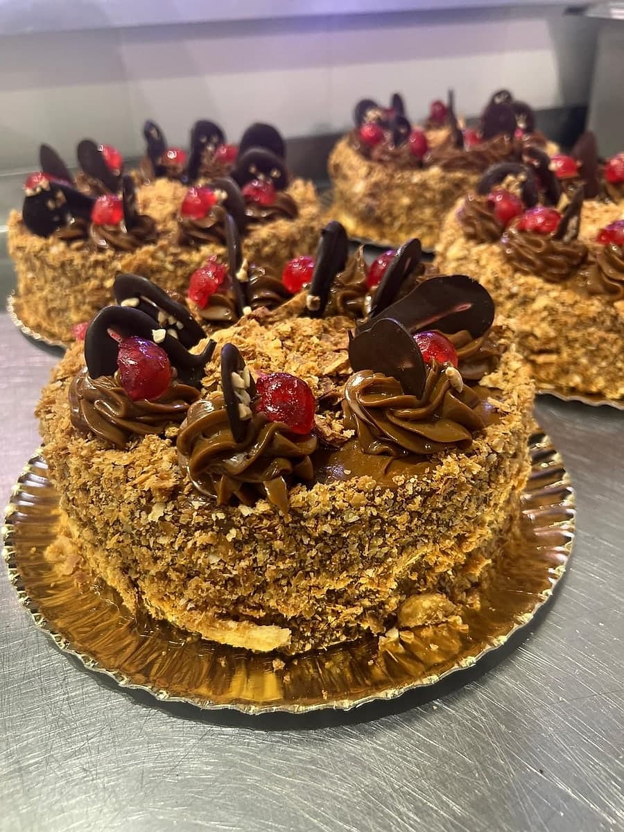 Tarta milhojas de hojaldre de Kerrico, con crocante de nueces alrededor y dulce de leche, cerezas y virutas de chocolate encima.