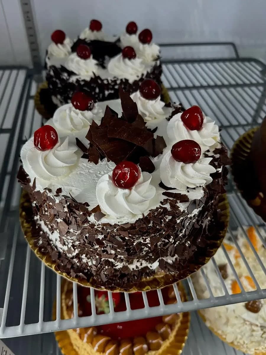 Tarta selva negra de Kerrico, cubierta de nata, virutas de chocolate negro y cerezas.